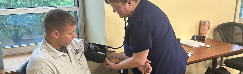 Employee health nurse taking a man's blood pressure