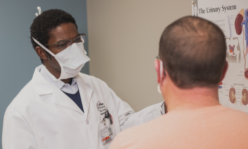 Dr. Yemi, a urologist, speaking to a patient.